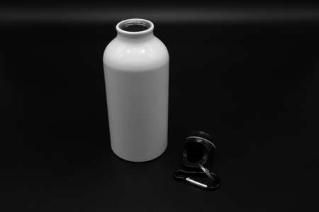 White travel flask with hook isolated on black background for attaching to a backpackの写真素材