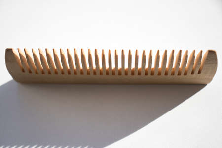 Thin comb of light wood on a white backgroundの写真素材