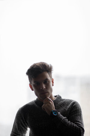 The man holds a hand on his chin, in a pensive posture and cunning eyesの写真素材