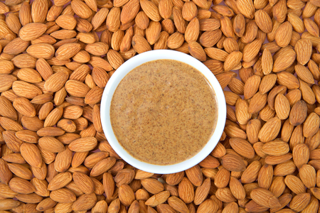 White bowl with fresh almond butter surrounded by almonod nuts. Almonds are California's third-leading agricultural product in the United States.の写真素材