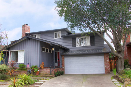 Two story ranch style house, gray wood siding with red brick work. Ranch style  is a domestic architectural style originating in the United States.のeditorial素材