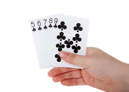 Young female hand holding Playing cards, a straight.  A straight  is five cards in sequence of of mixed suits. The straight that has the highest card is the winner. Clubs no face cardsの写真素材