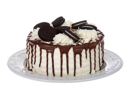 White whipped cream frosted cake on a porcelain plate, isolated on white backgroundの写真素材
