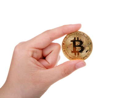 Young female hand holding physical golden bit coin depecting Digital Cryptocurrency currency isolated on white background.の写真素材