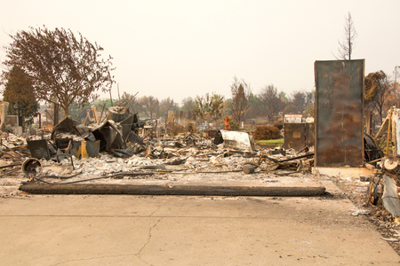 home burned to the ground in the recent wild fire fire storm in Redding, California. Smoke and ash in the air as the fire continues to burn several miles away.の写真素材
