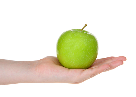Young female hand holding one delicious green apple in open palm isolated on white background.の写真素材