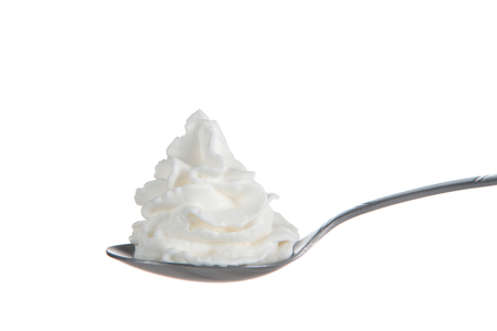 Whipped cream nicely curled on a spoon isolated on white background. Nitrous oxide fuels the expulsion of whipped cream from spray cans, which was recently in short supply due to a factory explosion.の写真素材