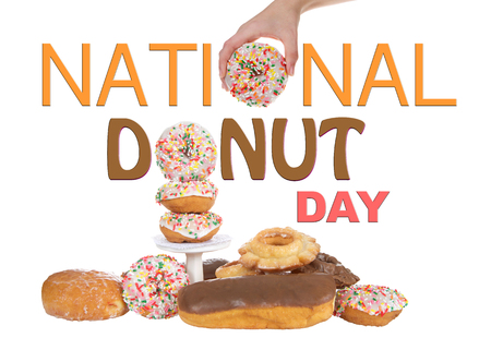 Variety of Donuts isolated on white background, National Donut Day in June and November. Hand holding donut for O in National and stacked donut for O in Donut.の写真素材
