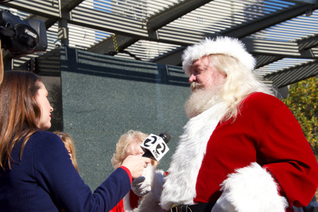San Francisco, CA - December 8, 2018: Tom DiBell, organizer of Santa Con, held at Union Square being interviewd by channel 2 news regarding the annual city wide Santas only pub crawl and toy donation to charity.のeditorial素材
