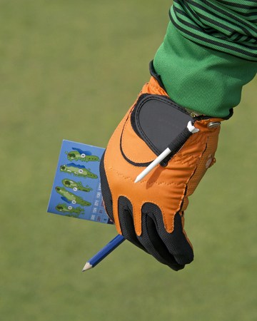 Male hand with golf score card keeping score. Holding the score card off to the side while his...