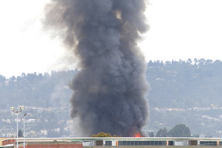 Smoke and flames shooting up from Oakland, CA warehouse fire April 1, 2019. Viewed from Alameda Island approx a mile awayのeditorial素材