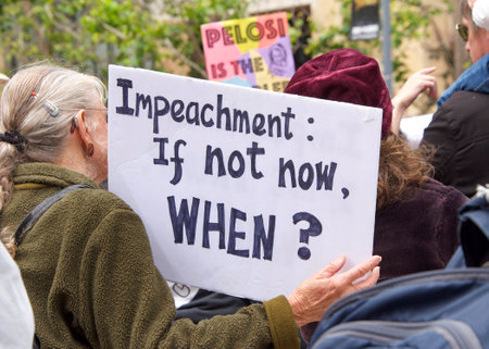 Oakland, CA - June 15, 2019: Unidentified protesters with signs in front of the Federal Courthouse, demanding an inquiry into the impeachment of Donald Trumpのeditorial素材