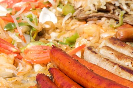 Hot dogs and sausages with onions, jalapenos, and several varieties of bell peppers and tomatoes...