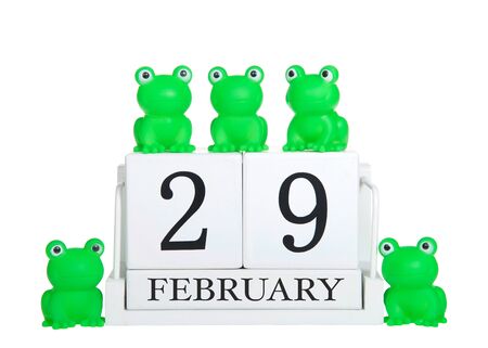 White calendar blocks February 29 isolated on white background with generic green frogs on and around calendar. Leap Year themeの写真素材