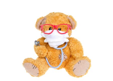 Little fluffy brown bear wearing a white face mask, pink glasses, holding a bear sized stethoscope looking at viewer, Isolated on white.の写真素材