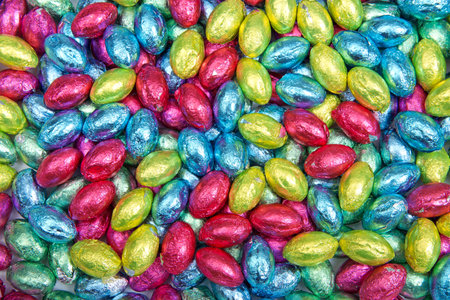 Close up background of Chocolate easter eggs covered with brightly colored foil wrappersの写真素材