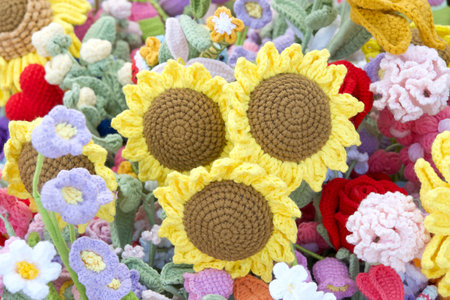 Bundle of hand crafted crochet sunflower flowers surrounded by colorful crochet spring flowers.の写真素材