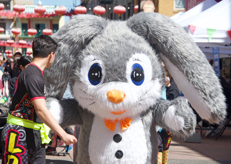 San Francisco, CA - April 15, 2023: Participants at the CYC Spring Festival at Waverly Place in Chinatown. Youth assisting giant bunny rabbit to navigate walking down the busy street.のeditorial素材