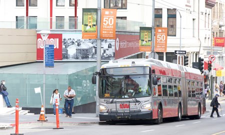 San Francisco, CA - Aug 12, 2023: Muni bus outside the Chinatown Rose Pak station. Celebrating 50 years signs hanging from the poles.のeditorial素材