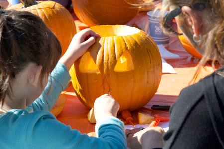 San Francisco, CA - Oct 23, 2023: Kids carving pumpkins at Senator Scott Wieners Halloween Pumpkin Carving Event at Noe Courts Park.のeditorial素材
