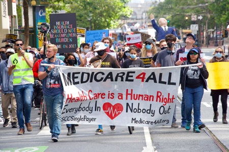 San Francisco, CA - July 24, 2021: Unidentified participants marching up Market Street to a rally at Civic Center in front of City Hall, demanding Medicare for All.のeditorial素材