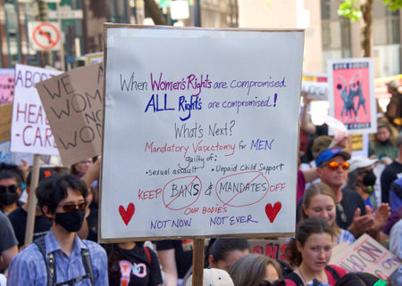 San Francisco, CA - May 14, 2022: Unidentified participants marching in the streets holding signs in...