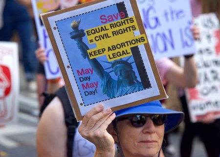 San Francisco, CA - May 14, 2022: Unidentified participants marching in the streets holding signs in...