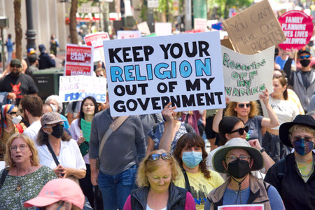 San Francisco, CA - May 14, 2022: Unidentified participants marching in the streets holding signs in...