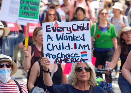 San Francisco, CA - May 14, 2022: Unidentfied participants marching in the streets holding signs in...