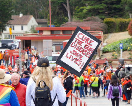 San Francisco, CA - June 4, 2022:  Wear Orange Stop Gun Violence March, participants marching to and across the Golden Gate Bridge holding signs demanding action against gun violence.のeditorial素材