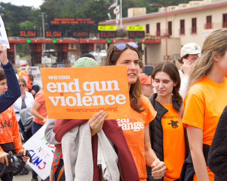 San Francisco, CA - June 4, 2022:  Wear Orange Stop Gun Violence March, participants marching to and across the Golden Gate Bridge holding signs demanding action against gun violence.のeditorial素材