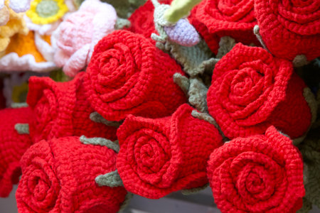Close up on hand crafted crochet vibrant red rose flowersの写真素材