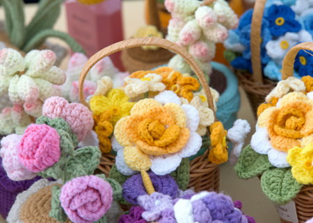 Close up on bouquets and baskets of beautiful hand crafted crochet flowers. Yellow, purple and pink rosesの写真素材