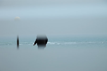 Lord walking through the city through a white opaque window and the seaの写真素材