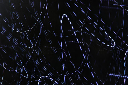 curves lines making with white lights on a dark backgroundの写真素材