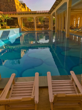 Empty chairs by the side of Swimming pool