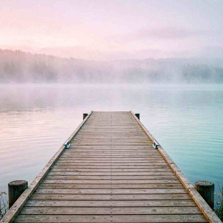 Wooden pier on a lake in the foggy morning. Beautiful landscape.