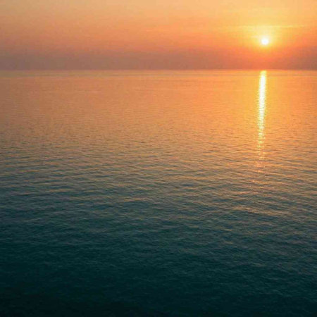 Sunset over the sea. View from above. The sun is reflected in the water.