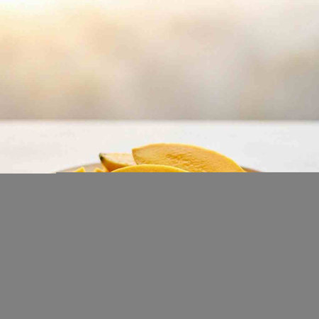 Sliced mango on white wooden table with blurred background. Selective focus.