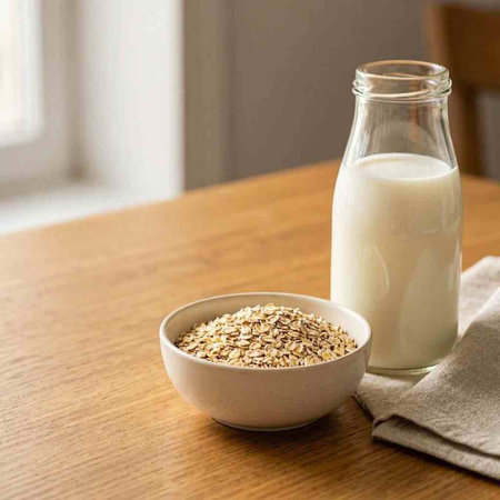 Oat flakes in a bowl and a bottle of milk on a wooden table