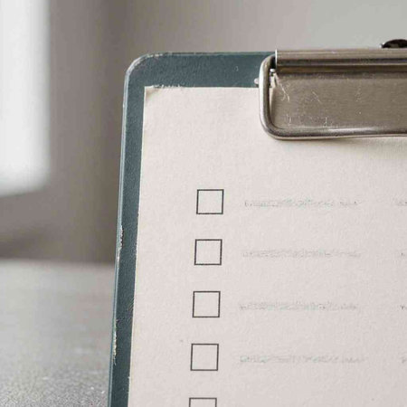 Clipboard with checklist on table, close-up, selective focus