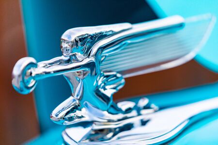 A Chrome Hood Ornament Looks Forward on a Blue Carの写真素材