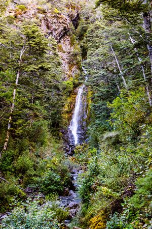 A Cold Waterfall Flows Down a Vibrant Valleyの写真素材