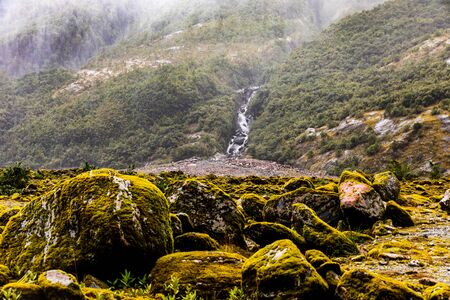 Mossy Rocks and a Waterfall Near Franz Josef Glacier