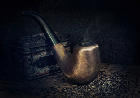 Smoking pipe and tobacco on a wooden table in a vintage styleの写真素材