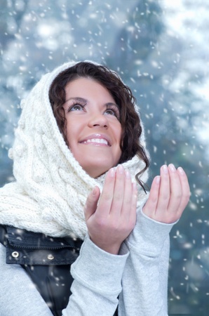 Pretty young caucasian brunette woman wearing white scarf with hood in a outdoor winter portrait 