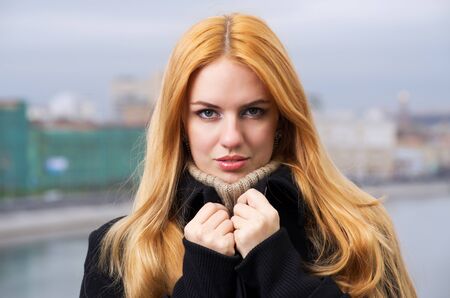 Young caucasian beautiful  redhead  woman against urban background.の写真素材