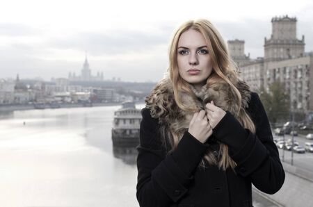 Young caucasian beautiful  redhead  woman against urban background.