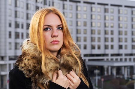 Young caucasian beautiful  redhead  woman against urban background.の写真素材