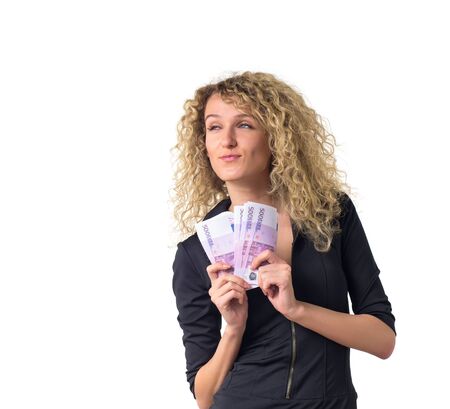 Attractive young business woman with curly hair counts money sly. Isolated against white background.